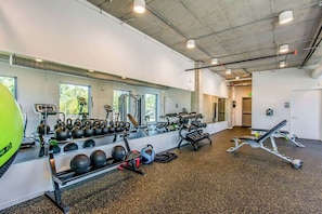 A gym with exercise equipment, a mirror, and a window. - Eco-Friendly Condo with Shared Seasonal Pool, Balcony, and Free WiFi (Nashville)