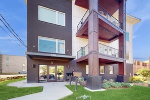 A multi-story building with a ground-level entrance, large windows, and a balcony on the upper floors. - Downtown West End Nashville Retreat, Near Broadway (Nashville)