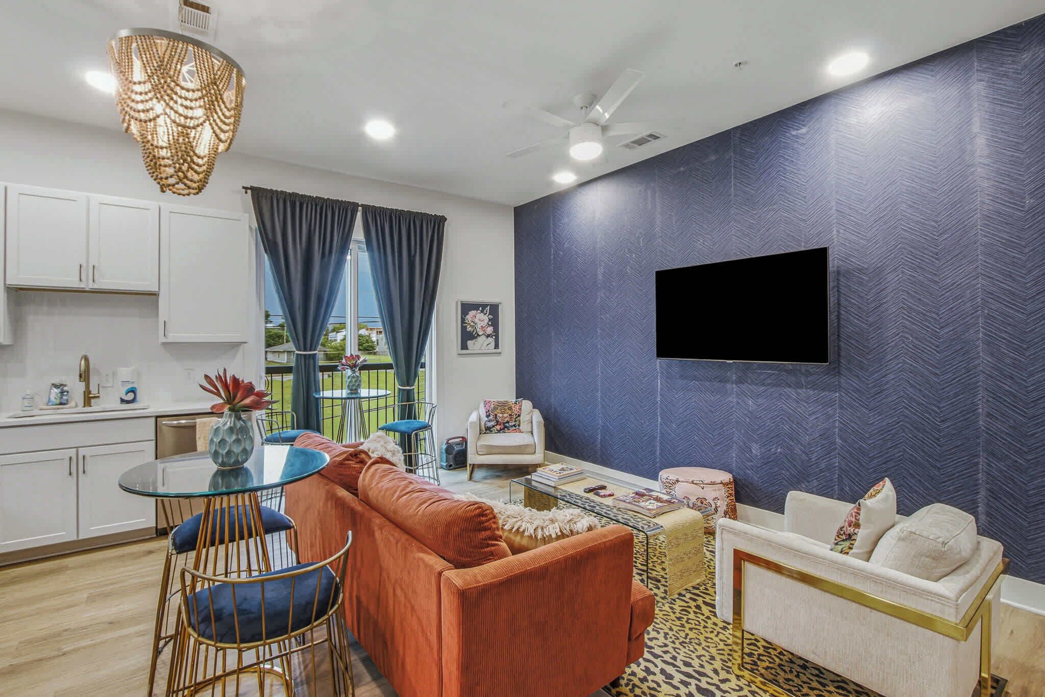 A modern living room with a sofa, a coffee table, and a TV mounted on the wall.