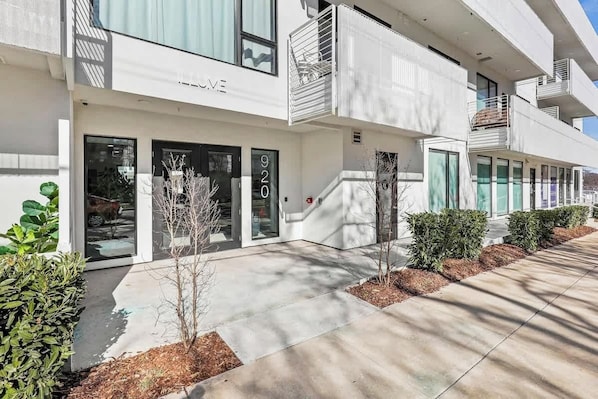 A modern building with a flat facade, large windows, and a visible address number. - Unique Gulch View Retreat with Balcony, Seasonal Pool, & Gym (Nashville)