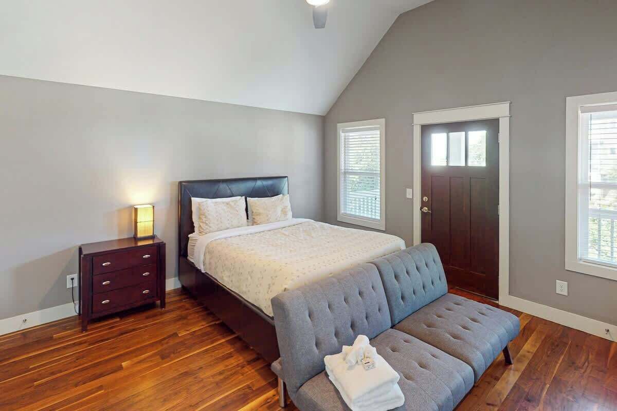 A bedroom with a bed, bedside table, and a bench.