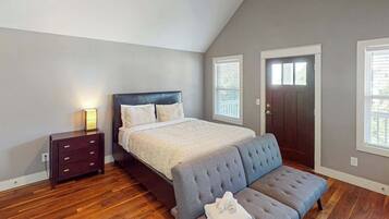 A bedroom with a bed, bedside table, and a bench.