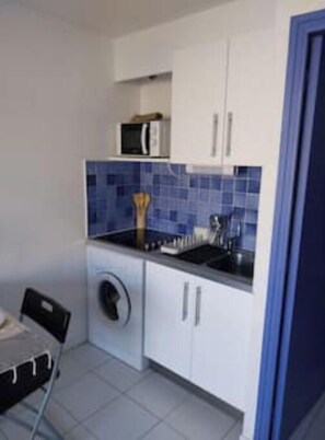 A compact kitchen with a washing machine, a microwave, and a sink. - Cosy studio for 4 people private residence (Sète)