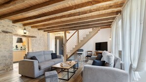 A spacious living area with a wooden ceiling, a staircase, and a modern sofa set. - Le Clos des Prés with Pool, Spa and Table Football (Rives de l'Yon)