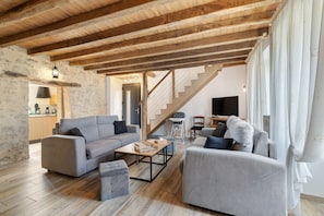 A spacious living area with a wooden ceiling, a staircase, and a modern sofa set. - Le Clos des Prés with Pool, Spa and Table Football (Rives de l'Yon)