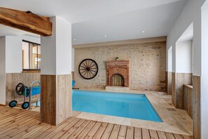 A swimming pool with a wooden deck, a brick fireplace, and a wheel. - Le Clos des Prés with Pool, Spa and Table Football (Rives de l'Yon)