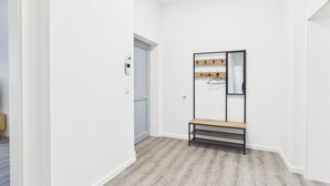 A hallway with a coat rack, a bench, and a door. - Family apartment with balcony, up to 5 guests - GÖ04 (Görlitz)