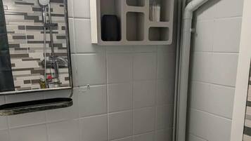 A bathroom with a sink, toilet, and a mirror.