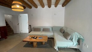 A living room with a wooden ceiling, a sofa, a coffee table, and a hanging light fixture. - Holiday Home 'Casa Baía Da Lagoa' with Sea View and Wi-Fi (Lagoa)