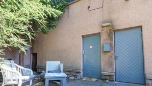 Ein Innenhof mit einer Bank, zwei Türen und einer Steinmauer.