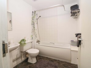 A bathroom with a toilet, sink, shower, and bathtub.