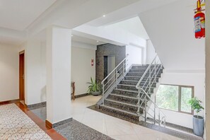 A modern interior with a staircase, a fire extinguisher, and a potted plant. - Townhouse Oak Sevoke Road Siliguri (Jalpaiguri)