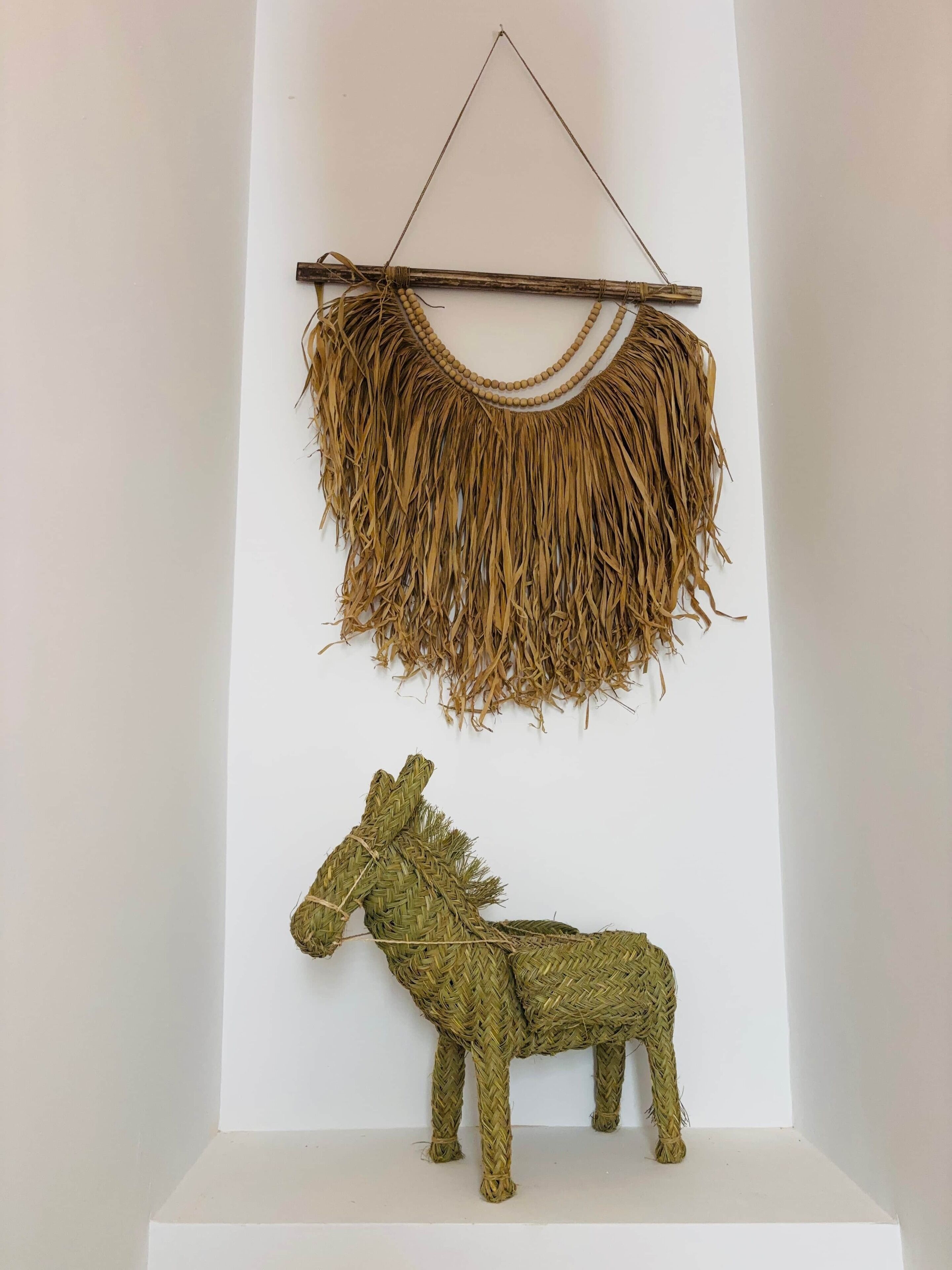 Een wanddecoratie met een geweven textuur en een ophangelement.