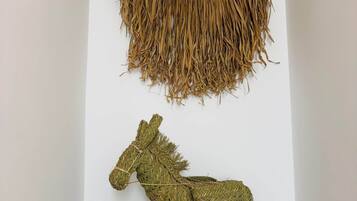 Een wanddecoratie met een geweven textuur en een ophangelement.
