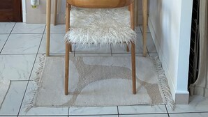 Un espace de travail comprenant un bureau, une chaise, des étagères et une lampe.