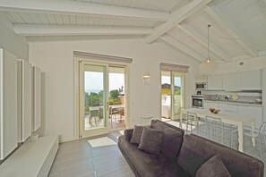 Una sala de estar moderna con un sofá, una zona de comedor y una cocina.