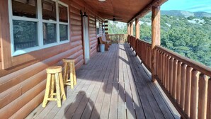 A wooden deck with a ceiling fan, wooden steps, and a view of a forested landscape. - NEW Klondike Cabin, Saguache CO (Saguache)