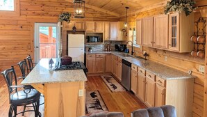 A wooden cabin interior with a kitchen, dining area, and a large window. - NEW Klondike Cabin, Saguache CO (Saguache)