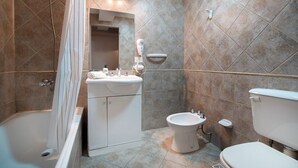 Un bagno con vasca, lavandino, bidet e WC.
