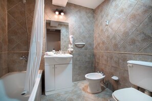 Ein Badezimmer mit Badewanne, Waschbecken, Bidet und Toilette.