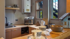 Una cucina con forno integrato, bollitore e una ciotola sul piano di lavoro.