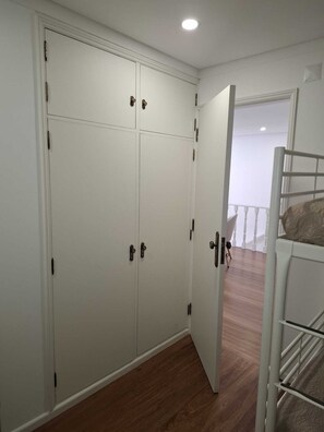 A room with a white wardrobe, a bunk bed, and a wooden floor. - 4 -As Floor 2 bedroom House Center (Guimarães)