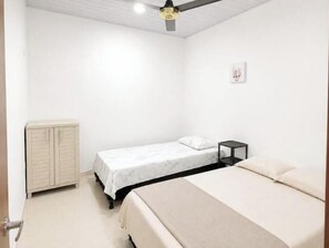 A bedroom with a bed, a nightstand, a wardrobe, and a ceiling fan. - Suitable for 11 people / Autocheck-in + parking / 4 rooms (Tolima)
