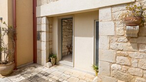 A stone building with a doorway, potted plants, and a tiled floor. - Country House 'Alla Corte Di Nonna Maria' with Air Conditioning (Modica)