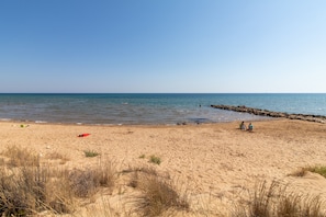 A beach with sand, sparse vegetation, and a calm sea. - Country House 'Alla Corte Di Nonna Maria' with Air Conditioning (Modica)