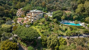 An aerial view of a modern resort with multiple buildings, a swimming pool, and lush greenery. - 223 Le Gla Euls in Golfe Juan (Vallauris)
