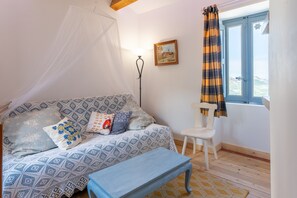 A room with a bed, a chair, a window with curtains, a lamp, and a painting on the wall. - Holiday Home 'U Casa Turchina' with Sea View, Private Terrace and Wi-Fi (Poggio-d'Oletta)