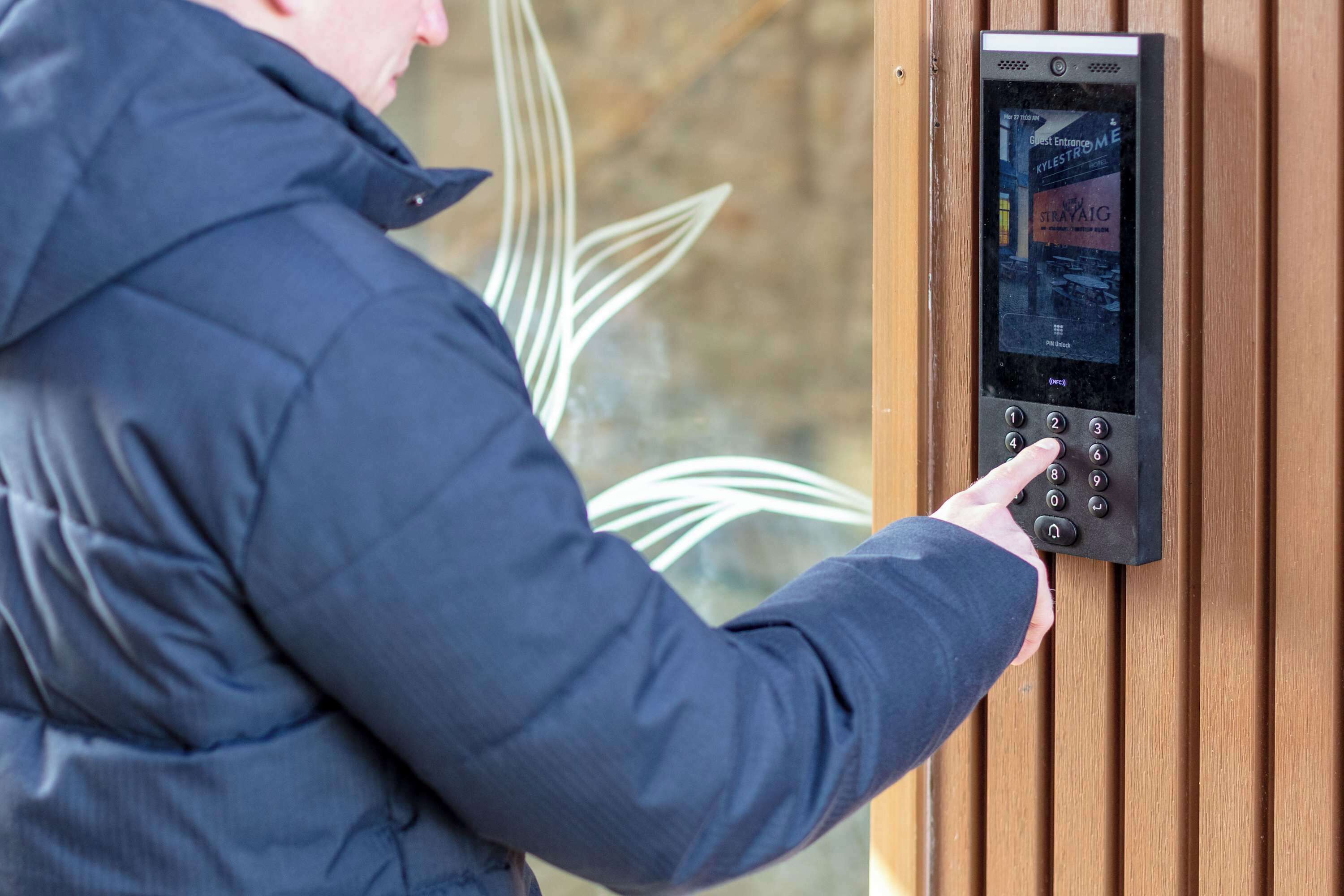 Una persona utilitzant un teclat digital per accedir a la habitació.