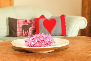 A wooden table with a plate of pink flowers. - FeWo Alpin 2 im Ferienidyll am Großen Wentowsee (Gransee)