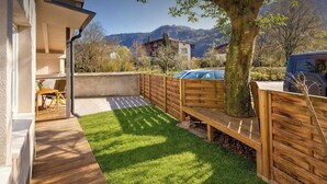 A backyard with a wooden deck, a barbecue grill, and a view of mountains. - BERGNEST – Private Terrace & Garden (Voldöpp)