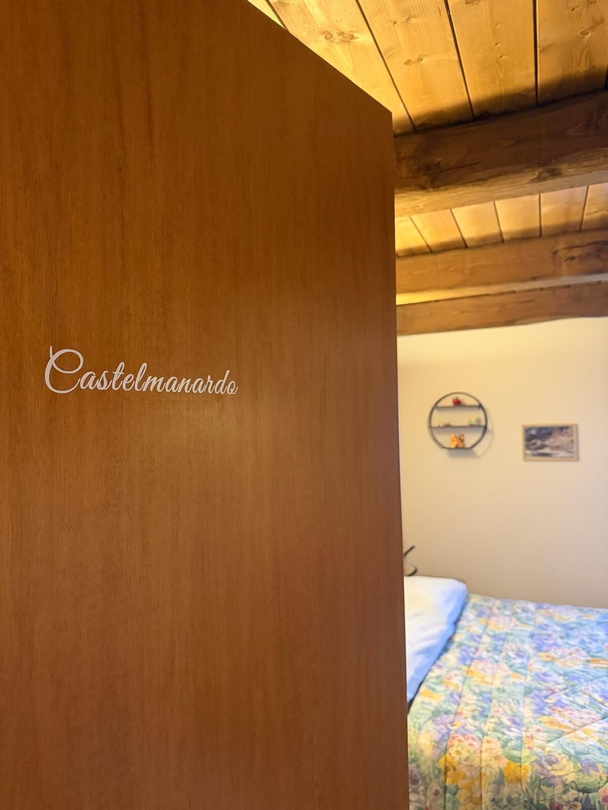 A wooden interior with a bed and a wall with a circular decoration.