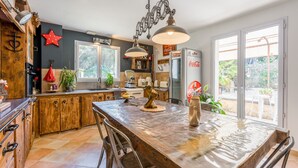 Une cuisine avec des meubles en bois, un grand îlot central et un réfrigérateur.