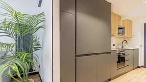 A modern kitchen with a built-in refrigerator, oven, and microwave. - GuestReady - Modern apartment in the city centre (Madrid)