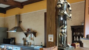 A kitchen with a chessboard, a robot figure, and wooden beams on the ceiling.