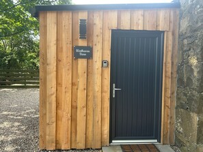 Een houten schuur-stijl gebouw met een zwarte deur en een naambordje met de tekst 'Westhaven Barn'.