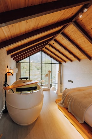A bedroom with a large bed, a round white chair, a wooden ceiling, and a large window. - Dd's Roof Villas (Ardesen)