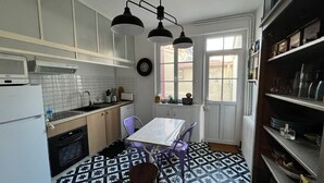 A compact kitchen with a dining table, chairs, and a window with a view. - Le logis des ais. Historic townhouse in city center (La Charité-sur-Loire)