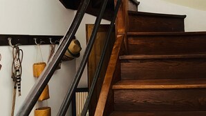 A wooden staircase with a metal handrail, a wall-mounted coat rack, and a framed picture. - Le logis des ais. Historic townhouse in city center (La Charité-sur-Loire)