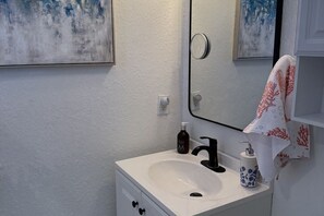 Een haardroger, handdoeken, zeep, toiletpapier