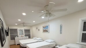 A hotel room with four single beds, a ceiling fan, a vanity with a mirror, and a window with blinds. - Shore House, Beach + Boardwalk, Parking for 7, Point Pleasant Beach (Point Pleasant Beach)
