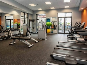 A gym with treadmills, weight machines, and exercise balls.