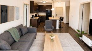 Ein modernes Wohnzimmer mit Sofa, Couchtisch und einem Essbereich mit Stühlen.