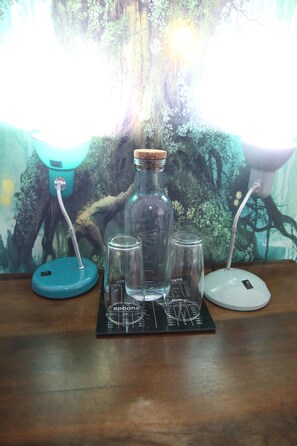 Une table en bois, une bouteille en verre, deux verres transparents et une balance.