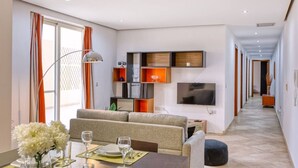 A modern living room with a sofa, dining table, and TV.