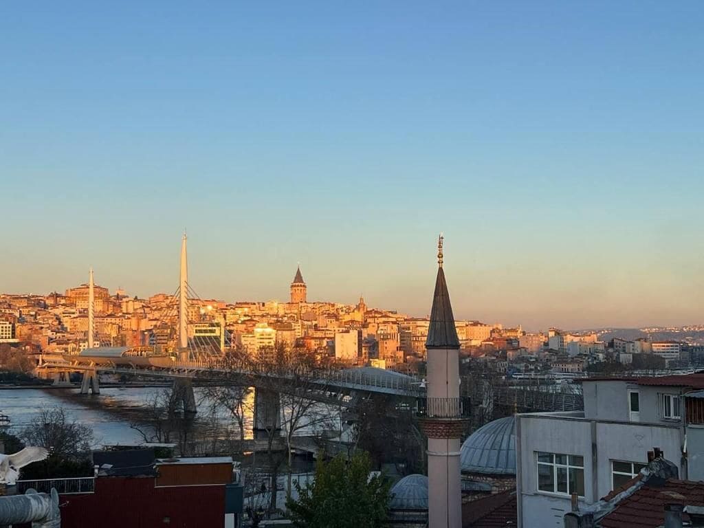 Un paisaje urbano con una mezquita destacada, un puente y un edificio con cúpula.