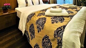 A hotel room with a bed, a nightstand, a painting on the wall, and a window with curtains. - Histavera Hotel (Istanbul)